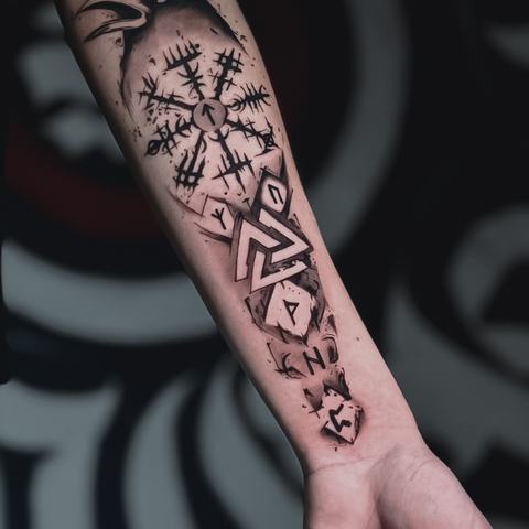 A graphic forearm tattoo built from Norse-inspired symbols, runes and geometric marks. Rough black lines give the piece a raw and distinctive aesthetic.