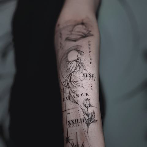 A delicate fine line forearm piece combining an eye, a female figure, botanical details, lettering and Roman numerals into a light conceptual composition.