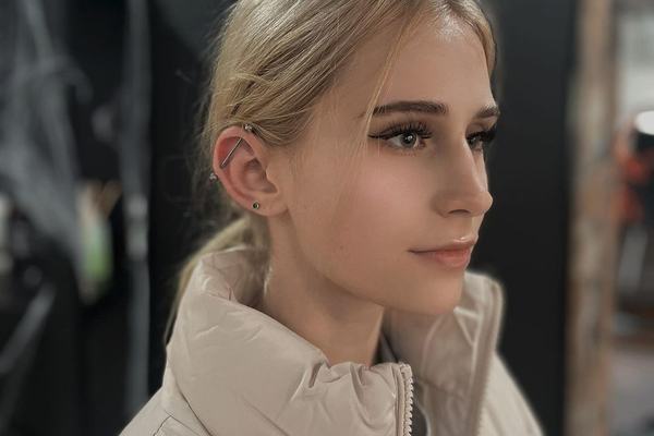 Profil osoby v salóne; ľavé ucho má helix a lalôčikový piercing so striebornými štiftmi – ukážka možností bezpečného, profesionálneho piercingu v Košiciach.