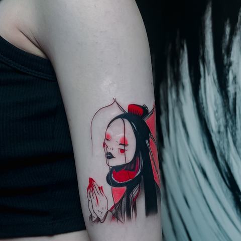 A stylised character tattoo inspired by anime aesthetics. Strong black areas and vivid red details give the design a bold, graphic and expressive appearance.
